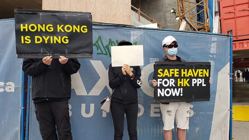 抗议者手持标语呼吁渥太华尽快推出 “安全港” 计划 (记者柳飞拍摄)