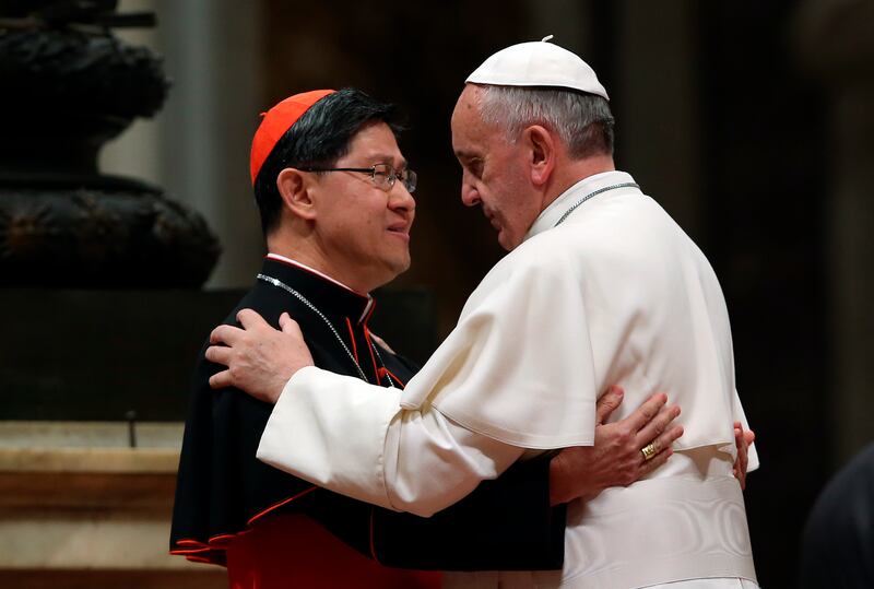 Pope Francis hugs Filipino Cardinal Luis Antonio Tagle (L) before blessing a mosaic of St. Pedro Calungsod's image during a meeting with the Philippine community at the St Peter Basilica in Vatican November 21, 2013. REUTERS/Alessandro Bianchi (VATICAN - Tags: RELIGION POLITICS)
