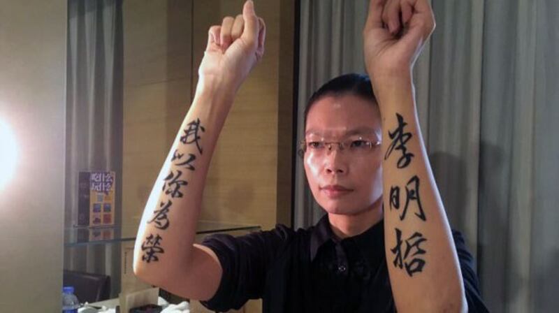 李妻李净瑜2017年9月11日赴陆会见丈夫，在双臂刺青“李明哲我以你为荣”力捍丈夫尊严。（资料照、李明哲救援大队提供）