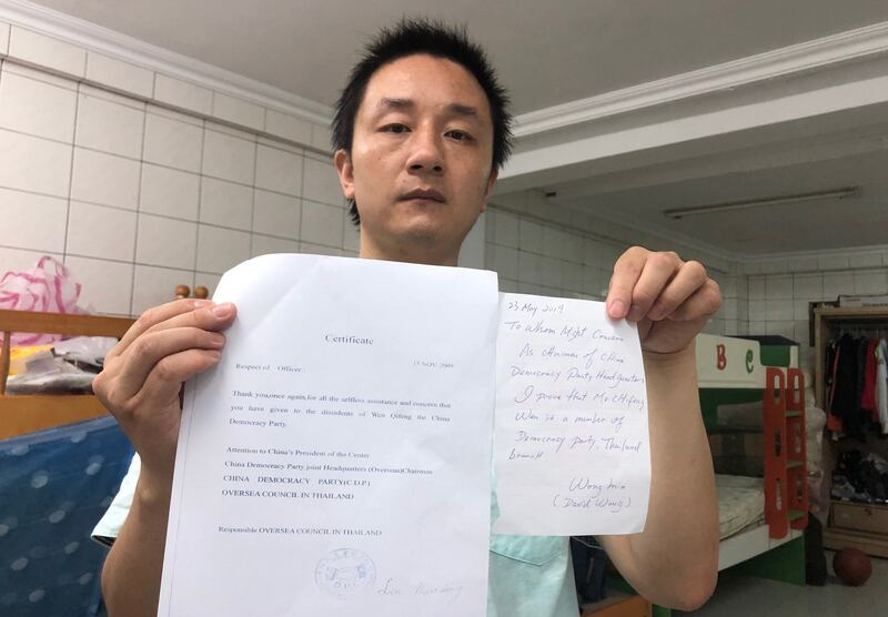 温起锋拿出两份中国民主党证明他是该党党员的文件,他说他左手这张是该党主席汪岷手签的文件,他希望对他取得身分更有利。(记者夏小华摄)