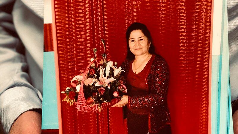 流亡美国的维吾尔人权活动人士乔达特(Ferkat Jawdat)手捧着的母亲画像(美联社)