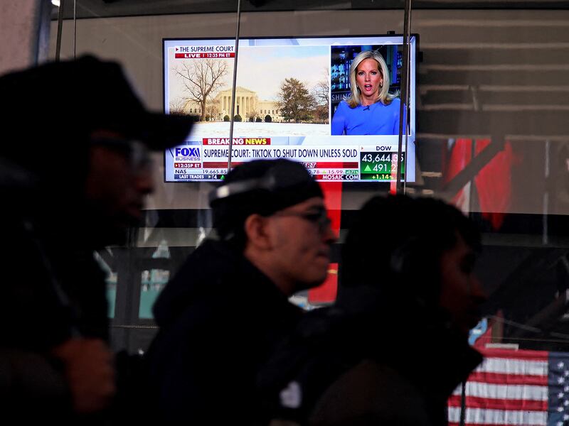 People walk past a television displaying a news broadcast about TikTok near Times Square in New York City, Jan. 17, 2025.