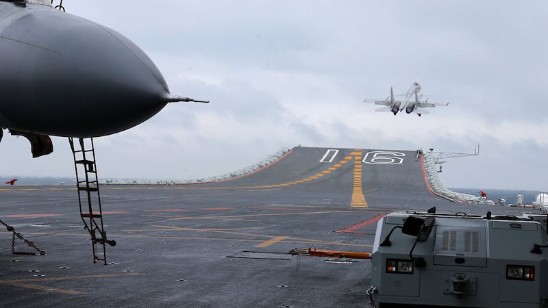 资料图片:2017年1月2日,中国航母编队以及歼-15舰载战斗机在南中国海海域进行起降和编队多科目训练。(法新社)