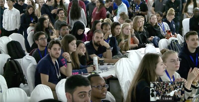 日前在卢安达召开的世界医学生联盟会长选举,台湾学生李柏锦(左上方穿白衬衫者)获六成选票,取得压倒性胜利。(世界医学生联盟直播网站截图)