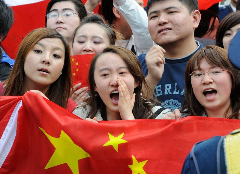 图为手举国旗的中国留日学生。近年来,选择赴日留学的中国学生人数激增。(美联社资料图片)