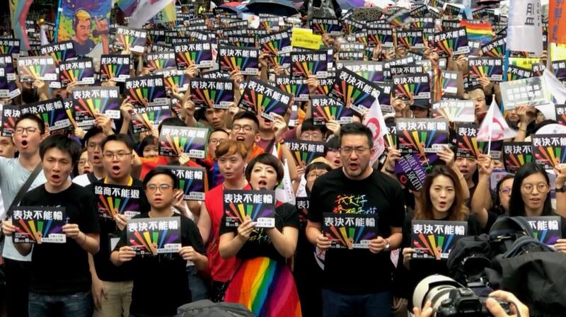 支持同性婚姻者从淋雨在场外守候。(记者夏小华摄)