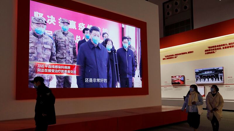 2020 年 12 月 31 日,在武汉会展中心举办的抗击冠状病毒病疫情展览,参观者走近展示习近平的屏幕。 (路透社)