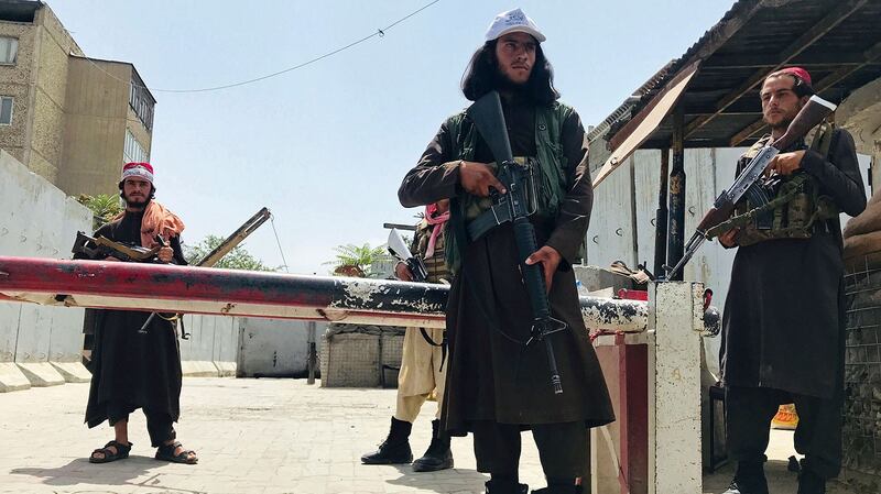 2021 年 8 月 17 日，塔利班战士在阿富汗喀布尔的一个检查站站岗。（美联社）