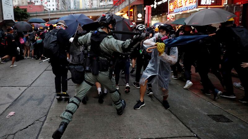 公报显示北京将进一步收紧对香港的政策,而港府也会加以配合,从严立法。图为2019年10月6日,香港集会期间一名防暴警察与一名抗议者发生冲突。(资料图/路透社)