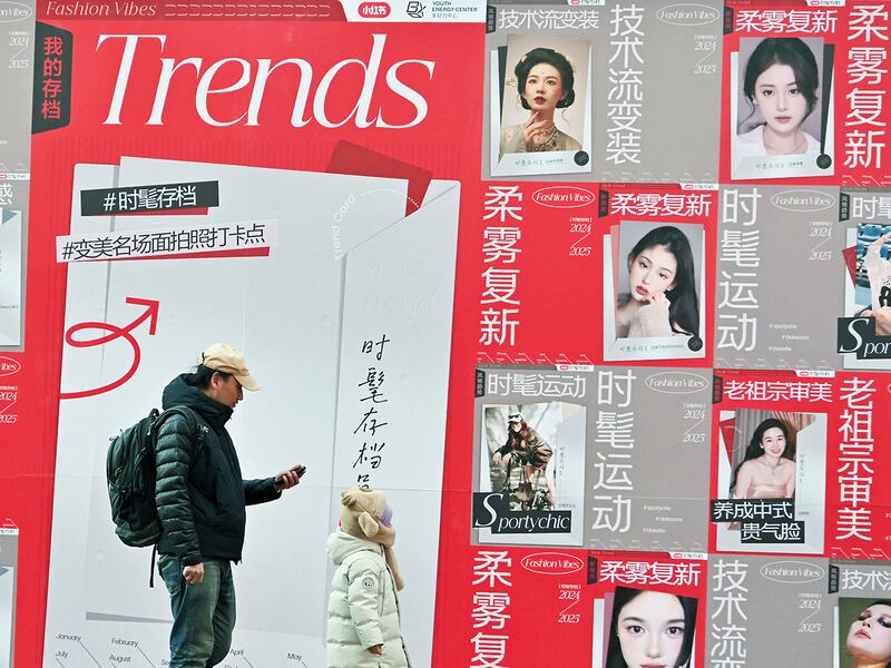 People walk past advertising for Chinese social networking and e-commerce app Xiaohongshu, also known as RedNote, at a shopping centre in Beijing, Ja