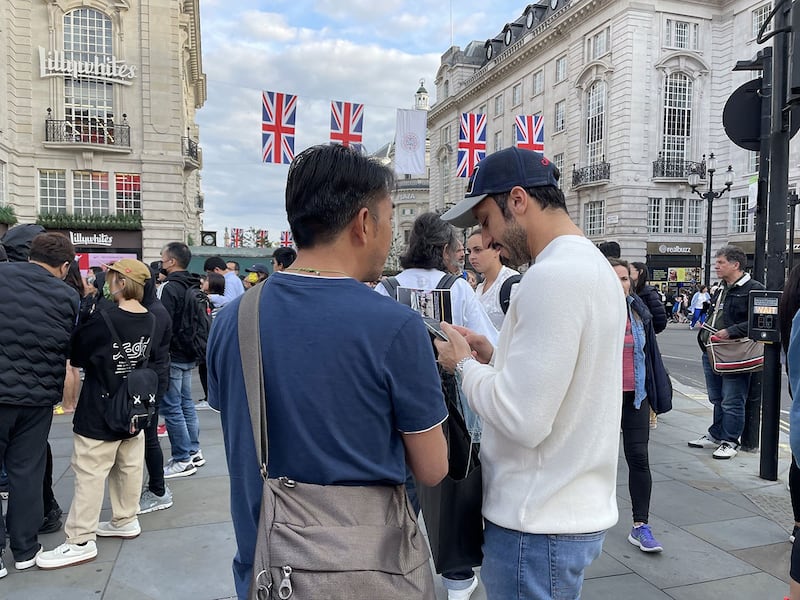 参与集会的港人Anthony努力向途人解释联署行动。 （吕熙摄）