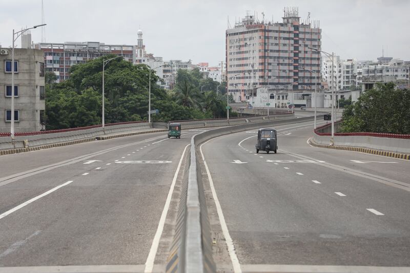 Two auto rickshaws are seen on an otherwise empty road during a nationwide curfew in the Jatrabari area in Bangladesh's capital, Dhaka, July 22, 2024. [Jibon Ahmed/BenarNews]