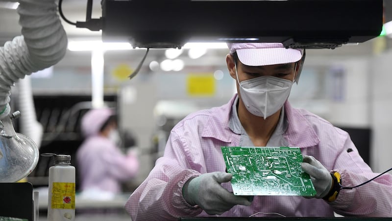 2021 年 8 月 16 日,湖北省武汉市,一名员工在检查格力工厂控制器生产线上的电路板。(路透社)