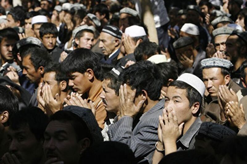 新疆民族村大部分男性被关进“再教育营”,与监狱无异。图为2006年10月13日,新疆维吾尔族人在斋戒月进行祈祷。(AFP)