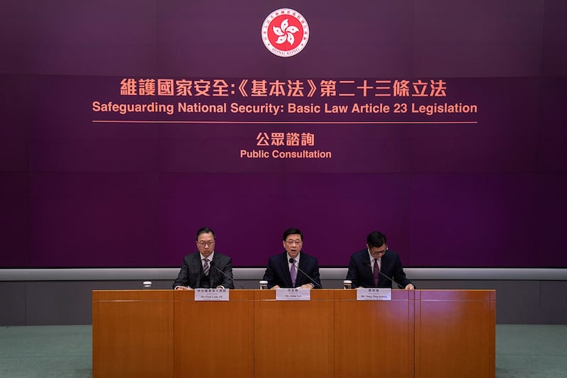 2024年1月30日,香港特区行政长官李家超(中)、律政司司长林定国(左)和保安局局长邓汉平在新闻发布会上宣布即日起展开23条立法公众咨询。(美联社)