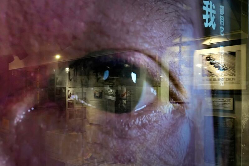 资料图片：一名民众的眼睛出现在电视屏幕上，一幅幅描绘 1989 年北京民主运动中图片在香港“六四纪念馆”展出。（美联社） .