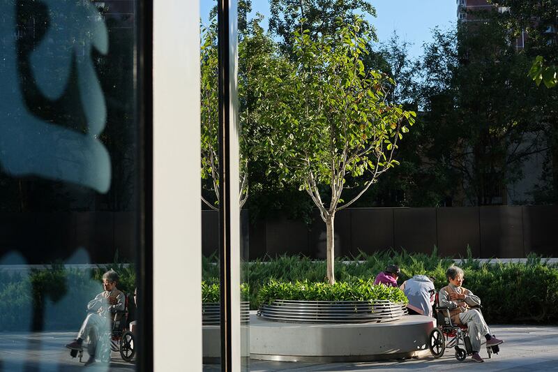 2024年10月7日,一位老妇人坐在北京购物中心的轮椅上。