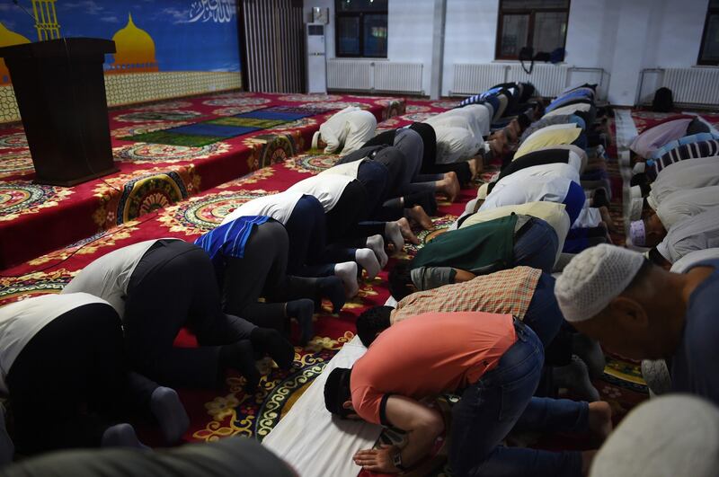 图为,2015年6月18日,穆斯林斋月的第一天,在北京的穆斯林们在一个清真寺内祷告。(法新社)