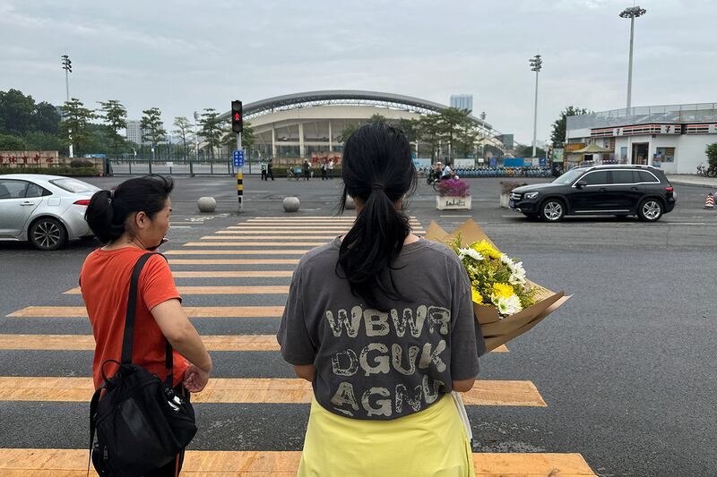 A woman holds a bouquet of flowers as she heads towards the sports center where a deadly car attack took place in Zhuhai, Guangdong province, China, Nov. 13, 2024.