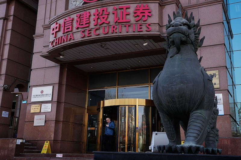 2024年2月6日，一名男子从北京中信建设证券走出。（美联社）