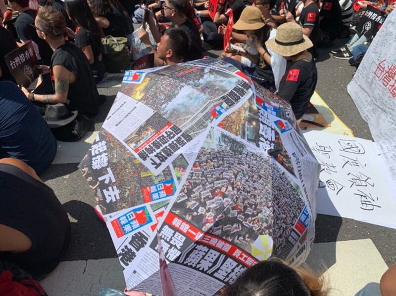 学生发挥创意,以简报自制雨伞“撑”香港。(记者 黄春梅摄)