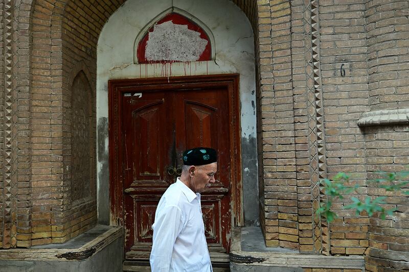 A Uyghur man walks past a closed mosque in Kashgar, in China's Xinjiang region, July 13, 2023.