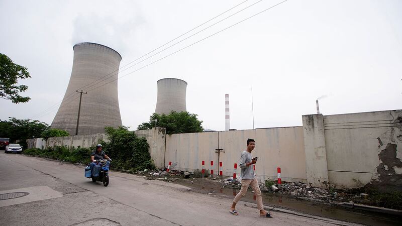 一名男子走过中国上海的一座燃煤电厂。(路透社)