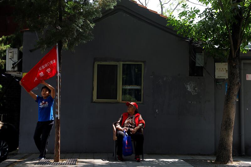 A member of a neighborhood party committee keeps watch along a street in Beijing, May 22, 2020.
