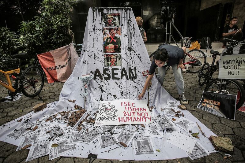 A woman sets a protest display with defaced pictures of Myanmar's junta leader Min Aung Hlaing in Jakarta, April 24, 2021. (Antara Foto/Dhemas Reviyanto via Reuters)