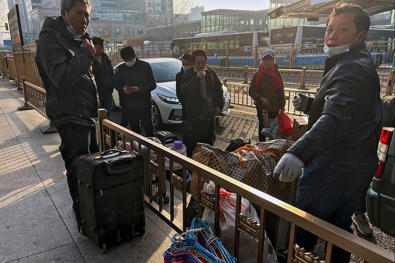 2023年1月6日携带行李在北京西站等候火车的农民工(美联社)