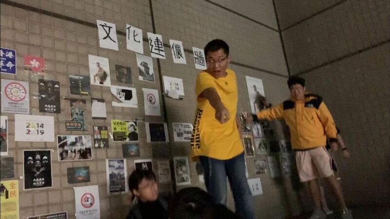 台湾的中国文化大学爆发港生贴连侬墙遭陆生撕毁、施暴。受害港生(下方)被台下女陆生拉下高台。(受害女港生提供)