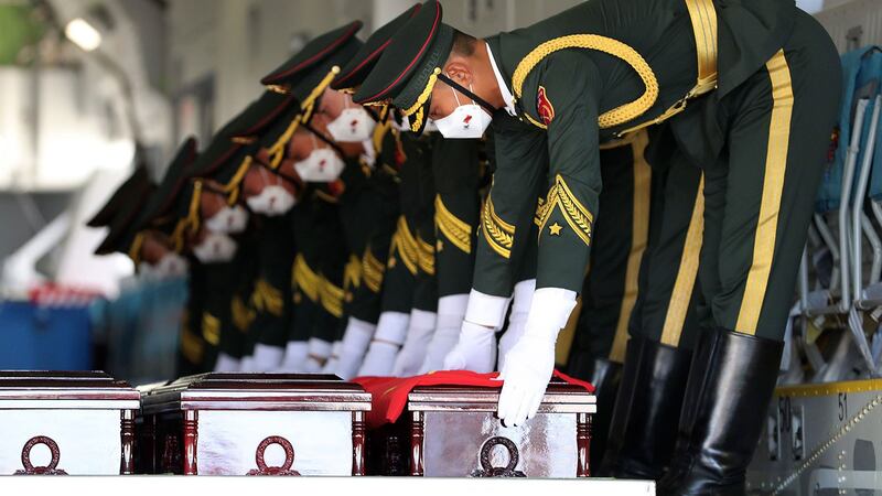 2020年9月27日,中方礼兵在韩国仁川国际机场交接仪式期间,将装有中国志愿军遗骸的棺材放在一架货机上。 (AP)